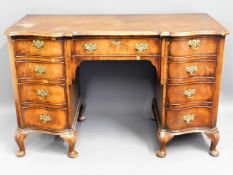 An antique walnut veneer on oak desk with brass fi