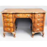 An antique walnut veneer on oak desk with brass fi