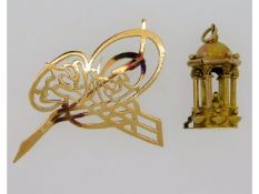 A 14ct gold charm twinned with a 14ct gold brooch,