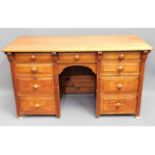 An antique light oak knee hole desk with nine drawers, 50in wide x 28in high x 21.5in