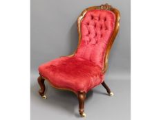 A 19thC. rosewood button back nursing chair, 35.5i