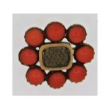 A yellow metal brooch set with coral, tests as gol