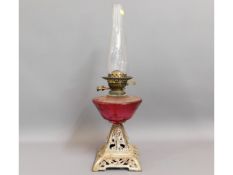 A c.1900 oil lamp with cast base & cranberry glass