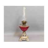 A c.1900 oil lamp with cast base & cranberry glass