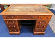 An antique mahogany veneered desk with nine drawer