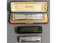 A large Hohner harmonica twinned with a Ludwig Any