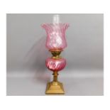 A Victorian brass oil lamp with cranberry font & l