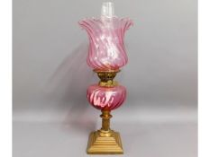 A Victorian brass oil lamp with cranberry font & l