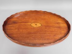 A large 19thC. mahogany tea tray with inlaid decor