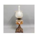 A c.1900 oil lamp with cast base & enamelled glass