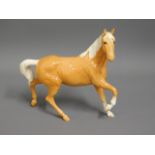 A Beswick palomino horse trotting, 8.5in tall