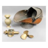 A copper coal scuttle, a bronze propeller, a brass