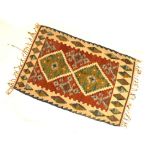 Small flat-woven kilim rug, brick-red field with two stepped lozenges, 81cm x 122cm Condition: