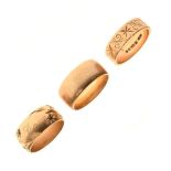 Three 9ct gold wedding bands, to include two with external engraved decoration, sizes M, O, and O½