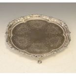 Victorian silver salver with beaded shaped rim, engraved floral decoration and standing on three