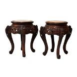 Pair of Oriental carved circular topped occasional tables, on four cabriole supports, 46cm high