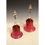 Two Nailsea-style cranberry glass bells, both with clear handles, largest 34.5cm high Condition: