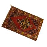 Middle Eastern wool rug, brick-red field with stepped central lozenge, 93cm x 155cm Condition: **