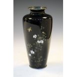 Japanese cloisonne enamelled vase decorated with a bird flying over flowering shrubs on a black