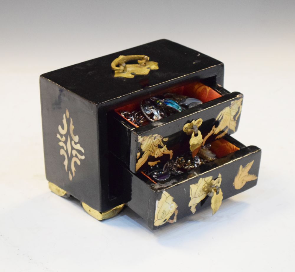 Oriental black lacquer jewellery chest containing a selection of white metal and enamel brooches,