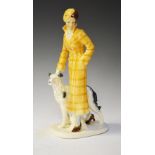 Art Deco-style glazed pottery figure of a woman walking a dog, 32cm high Condition: Crazing to the