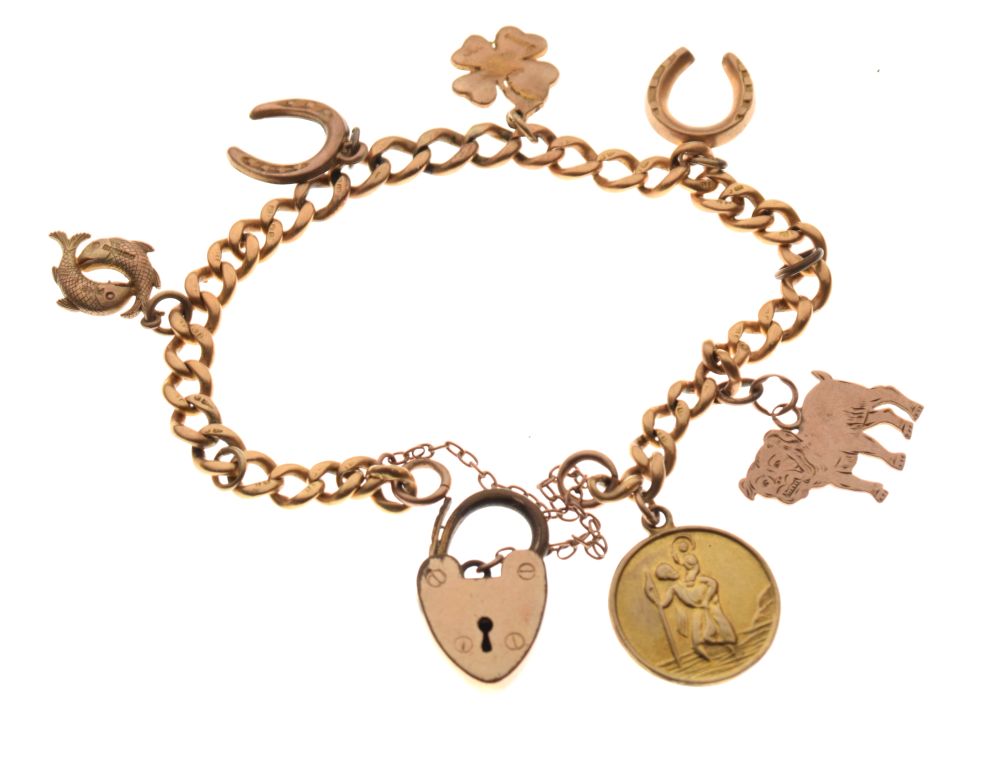 18ct gold curb link bracelet set with assorted gold and yellow metal charms and a plated padlock,