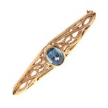 9ct gold bar brooch of pierced foliate scroll design set central faceted oval blue stone, 4.5cm