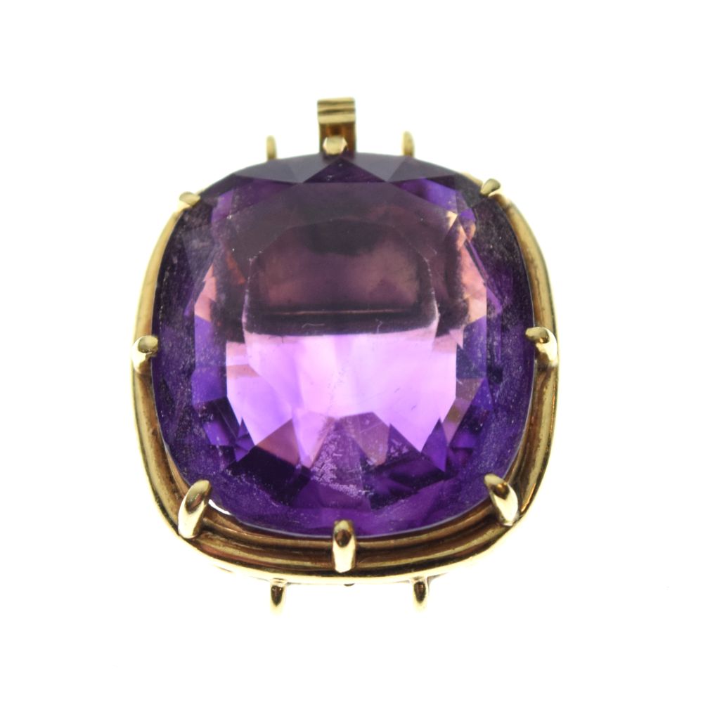 Faceted amethyst-coloured stone of approximately 17mm x 18.5mm, within yellow metal tonneau frame