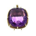 Faceted amethyst-coloured stone of approximately 17mm x 18.5mm, within yellow metal tonneau frame