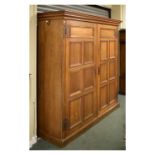 Early 20th Century oak double wardrobe with panelled doors enclosing hanging space, Arts & Crafts-