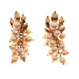 Pair of unmarked yellow metal and cultured pearl ear studs of leaf design, the pearl drops formed as