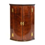 George III mahogany crossbanded bow front corner cabinet, 71cm x 48cm x 104cm Condition: Splits to