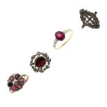 Four yellow metal dress rings, three of these set various red stones, the fourth marcasite, all