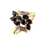 Yellow metal dress ring set S-shaped arrangement of faceted teardrop-form dark stones between