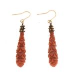 Pair of unmarked yellow metal and carved coral drop earrings, approx 3.5cm long excluding wire