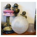 Four oil lamps with three glass shades Condition: Some dents to reservoirs and casing - **Due to