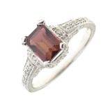 White metal dress ring set rectangular amethyst-coloured emerald-cut stone between small diamonds,