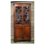 19th Century oak and mahogany floor standing corner cabinet, the upper section with two astragal-