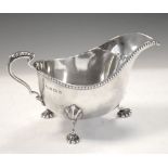 Edward VIII silver sauceboat with scroll handle and standing on three shell feet, 8.5cm high, 155g