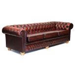 Large deep-buttoned red leather Chesterfield three-seater settee, approx 260cm wide Condition: **Due