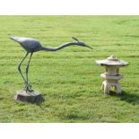 Lead garden statue in the form of a stylised heron attached to a stone base, together with a stone