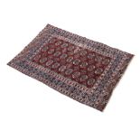 Middle Eastern wool rug of Afghan or Tekke Turkoman design with three rows of nine quarter guls,