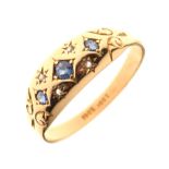 Yellow metal dress ring set three sapphires and four small gypsy-set diamonds, shank stamped '18ct',