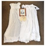 Two christening gowns, 101cm long and 92cm long, together with a photograph of a young boy wearing a