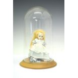 Small bisque doll of a girl in a blue dress within glass domed case, dome 28cm high Condition: