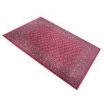 Modern machine made wool rug having central oval panel decoration on a red ground, 160cm x 230cm