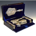 Cased five piece Edward VII silver backed dressing table set of four brushes and one mirror,