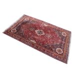 Middle Eastern wool rug, having typical decoration on a red ground, 169cm x 262cm approx