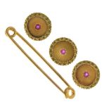 Three yellow metal (9ct) ruby-set buttons