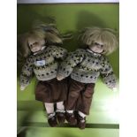 Two Stockinette boy and girl dolls dressed in cord skirt and trousers with knitted jumpers.